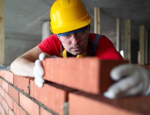 mason-builder-carefully-lays-red-brick-on-wall